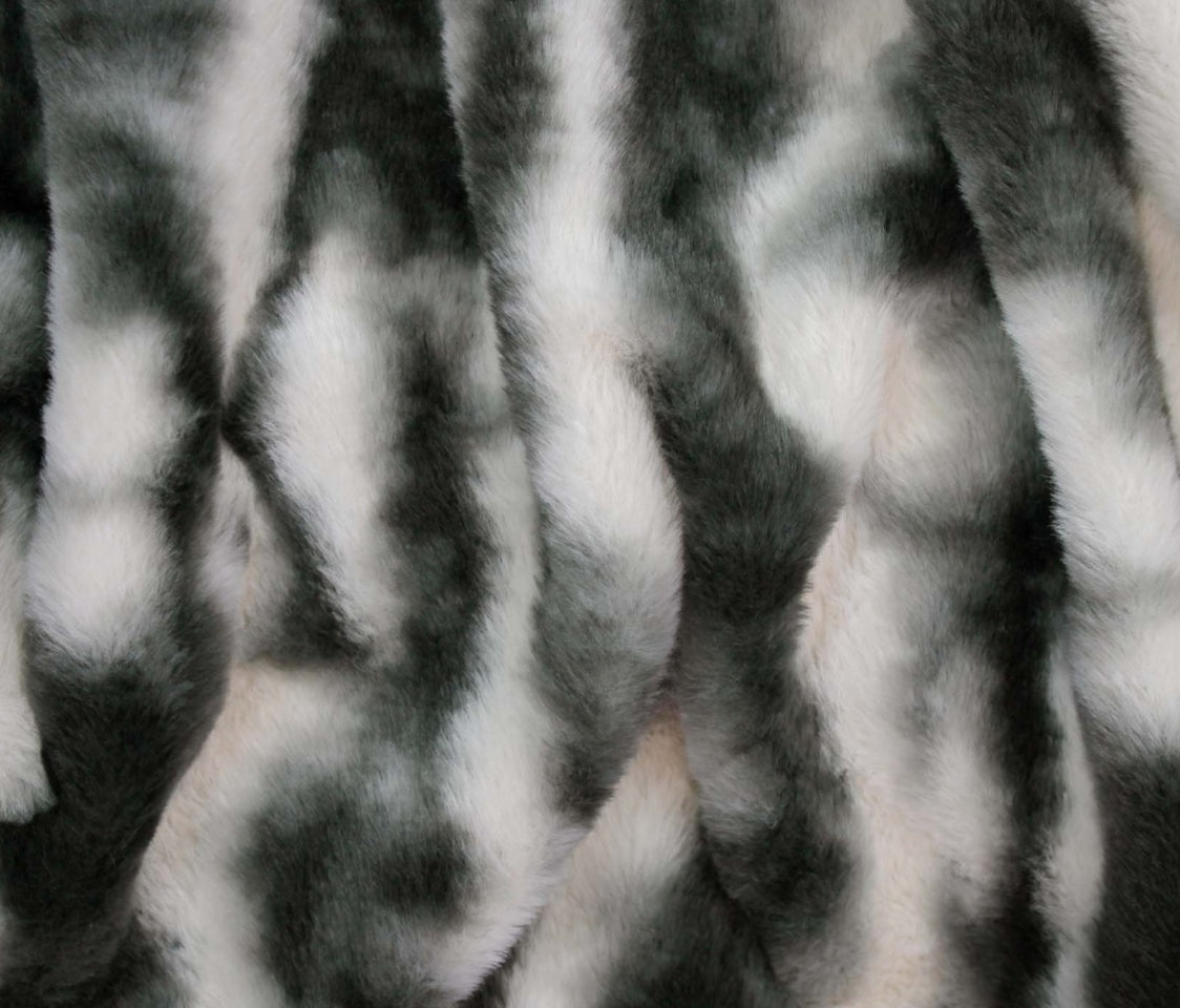A close-up of faux fur fabric with a black and white mottled pattern, showing the soft texture and vertical folds.