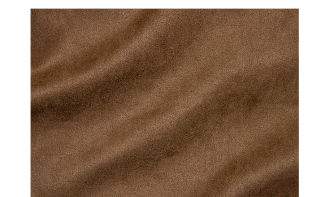 A close-up of brown suede or microfiber fabric with soft folds and a matte texture.