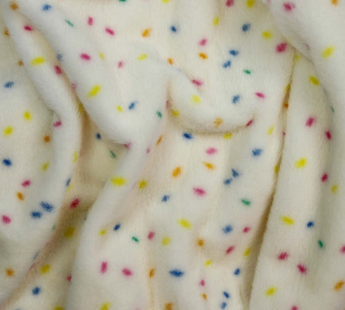 Close-up of a soft plush fabric in off-white with scattered small multicolored confetti dots in yellow, blue, pink, and orange.